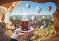 Morning cup of tea with view of colorful hot air balloons