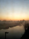 Morning dawns misty with cloudless sky above North London canal and moored boats Royalty Free Stock Photo