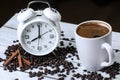 Retro alarm clock, coffee beans and cinnamon on a wooden table . Black background . Morning. Espresso . Wake up.
