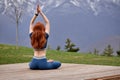 Morning Exercises in mountains landscape. Young red-haired Woman doing Yoga outdoor in morning