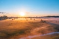 Morning fog in the meadows and at the mouth of the river during sunrise in the countryside, aerial view height of the landscape on