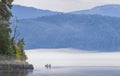 Morning fog over a mountain lake. Fishermen on the boat Royalty Free Stock Photo