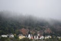 morning fog on the red cliffs in Trier with colorful houses below
