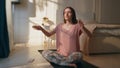 Morning girl doing yoga in sunlight home. Calm relaxed woman in lotus position