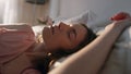 Morning girl open eyes in sunlight closeup. Peaceful smiling woman waking up Royalty Free Stock Photo
