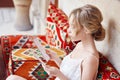 Morning girl resting sitting on a Turkish sofa. A woman in light clothes is preparing for the arrival of her beloved man Royalty Free Stock Photo