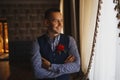 Morning of the groom. Groom morning preparation. Young and handsome groom getting dressed in a wedding shirt