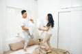 Morning of happy young couple fighting pillows in bedroom Royalty Free Stock Photo