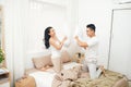 Morning of happy young couple fighting pillows in bedroom Royalty Free Stock Photo