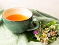 Morning herbal tea cup and summer flowers near window view on blue green cotton napkin background Royalty Free Stock Photo