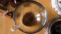 Morning hot beverage preparation. Concept. Top view of woman hands putting a spoon of instant coffee and a sugar cube