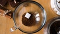 Morning hot beverage preparation. Concept. Top view of woman hands putting a spoon of instant coffee and a sugar cube