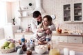 Pretty long-haired young woman in a white shirt and her husband standing in the kitchen Royalty Free Stock Photo