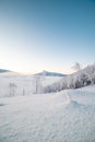 Morning idyll on the top of a snow-covered mountain with the rays of the sun irradiating the clouds, the ice cap of the mountain