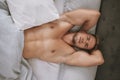 This morning just got sexy. High angle portrait of a handsome and muscular young man lying in his bed at home. Royalty Free Stock Photo