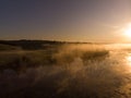 Morning on the lake in the forest with fog or steam on the background of the sun Royalty Free Stock Photo