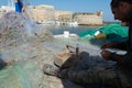 Morning landscape photo made in Gallipoli pier, fishermen reparing his fishermen net after fishing, Apulia, Italy