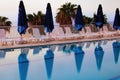 Morning landscape view of empty chaise lounges and sun umbrellas near swimming pool Royalty Free Stock Photo