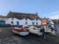 A thatched cottage and fishing boats in Sennen Cove, Cornwall, England Royalty Free Stock Photo