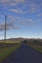 Morning light on the hills of the Angus Glens seen from the shadows of the Valley floor and a minor Scottish Road