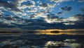 Morning light reflection in lake Malaren in Sweden, Sky reflected in calm water dramatic clouds, Golden horizon