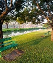 Green iron bench beneath trees near waterside at Suanluang park Bangkok