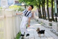 A little boy in China and his little Yorkshire dog stood in front of the fence.