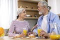 Morning Meal. Happy Senior Spouses Eating Breakfast And Chatting In Kitchen Royalty Free Stock Photo