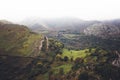 Morning mist house in the mountain peaks on natural landscape. Green valley on background foggy dramatic sky, mountain tops Royalty Free Stock Photo