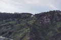 Morning mist in the mountain peaks on natural landscape. Green valley on background foggy dramatic sky, house in horizon perspecti Royalty Free Stock Photo