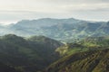 Morning mist in the mountain peaks on natural landscape. Green valley on background foggy dramatic sky. Panorama horizon perspecti Royalty Free Stock Photo