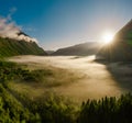 Morning mist over the valley among the mountains in the sunlight. Fog and Beautiful nature of Norway aerial footage Royalty Free Stock Photo