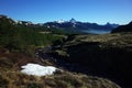 Morning mountain landscape, Patagonia, Small river, grassy meadow, snow patch, View over mountain range of Quinquilil Royalty Free Stock Photo