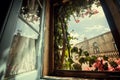 Morning in old house window, with garden flowers and historical building behind. Romantic vacation concept Royalty Free Stock Photo