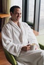 Morning portrait of handsome young man with cup of coffee