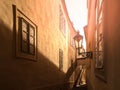Morning Prague scene. Sunlit and long shadows on the wall with gas street lamp, Thunovska Street, Lesser Town, Prague