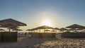Morning on the Red Sea beach. The rays of the sun illuminate the lattice umbrellas