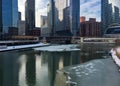 Morning reflections of cityscape in Chicago with interesting cloudscape over icy Chicago River in winter. Royalty Free Stock Photo