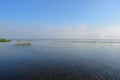 Morning river fog creeps over the water beautiful view blue sky clouds reflected in the water Royalty Free Stock Photo