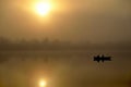 Morning. river, silhouette of a boat and fishermen, beautiful sunlight, reflection in the water of trees and the sun, a married Royalty Free Stock Photo