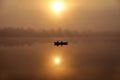 Morning. river, silhouette of a boat and fishermen, beautiful sunlight, reflection in the water of trees and the sun, a married Royalty Free Stock Photo