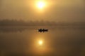 Morning. river, silhouette of a boat and fishermen, beautiful sunlight, reflection in the water of trees and the sun, a married Royalty Free Stock Photo