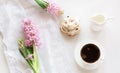 Morning romance breakfast, cup of coffee, milk jug and cake with decor of pink hyacinth. Spring concept. Royalty Free Stock Photo