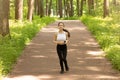 Morning run in the park. Young girl in headphones goes in for sports Royalty Free Stock Photo