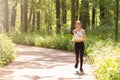 Morning run in the park. Young girl in headphones goes in for sports Royalty Free Stock Photo