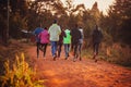Morning running training. in Kenya. Marathon runners on red soil train in the light of the rising sun. Motivation to move.