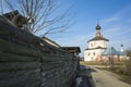 Morning in Russian town Suzdal in spring, Fluffy cat sitting on high raw wooden fence, Old Orthodox church on a distance Royalty Free Stock Photo