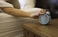 woman hand  in bedroom trying to wake up with alarm clock feeling Exhausted and overworked working in the night Royalty Free Stock Photo