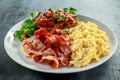 Morning Scrambled egg, bacon breakfast with beans in tomato sauce on toasted bread on white plate