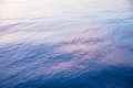 Morning at the seaside. Water background with ripples blue and light pink